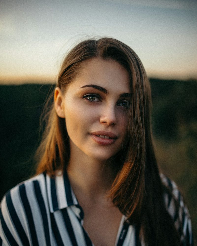 Portrait von Aylin, Inhaberin, mit langen dunklen Haaren und gestreifter Bluse im Abendlicht