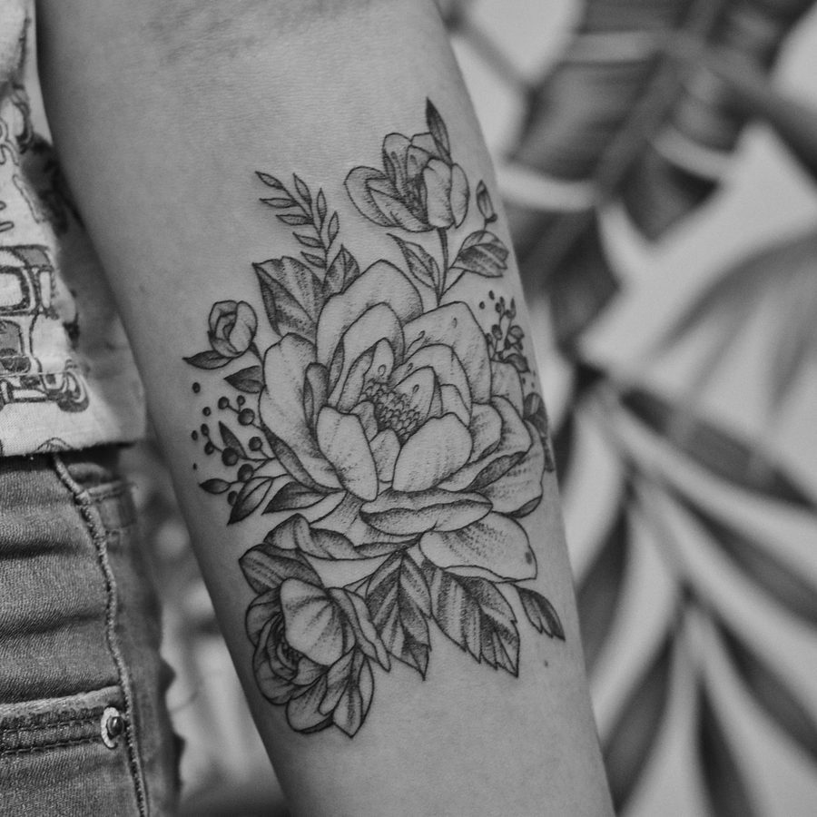 Linework: Pfingstrose mit Blättern als feine Linienzeichnung am Unterarm, schwarz-weiß