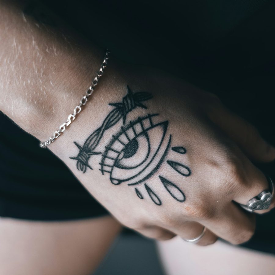 Blackwork: grafisches Auge mit Tropfen auf dem Handrücken